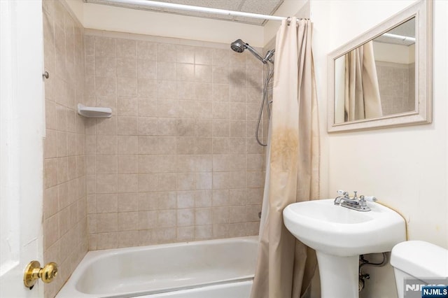 bathroom featuring shower / tub combo and toilet