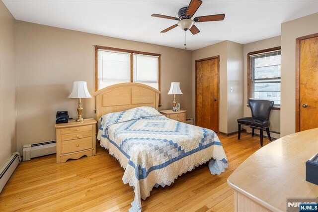 bedroom with a baseboard radiator, light wood-style floors, and a ceiling fan