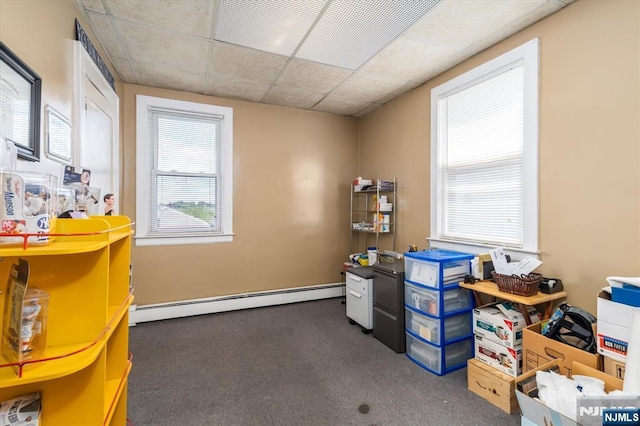misc room featuring a baseboard heating unit, carpet flooring, and a drop ceiling