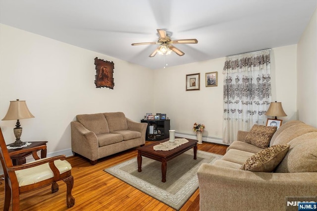 living area featuring light wood finished floors, ceiling fan, and baseboards