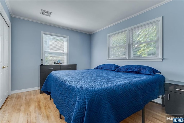bedroom featuring light wood-type flooring, multiple windows, baseboards, and ornamental molding