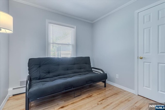 sitting room featuring wood finished floors, ornamental molding, baseboards, and baseboard heating