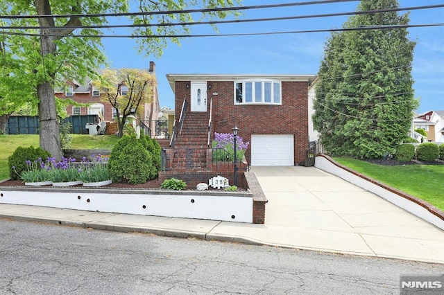 view of front facade with concrete driveway, stairway, brick siding, and a garage