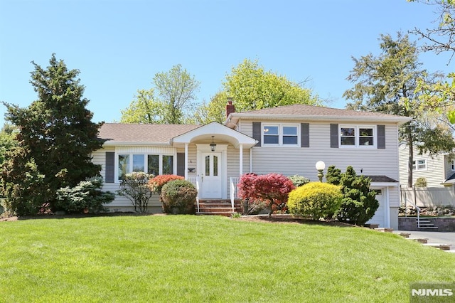 split level home featuring a chimney and a front yard