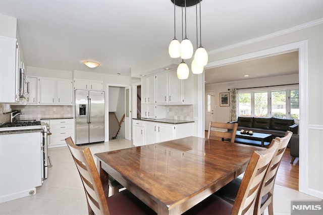 dining area featuring ornamental molding and light tile patterned flooring