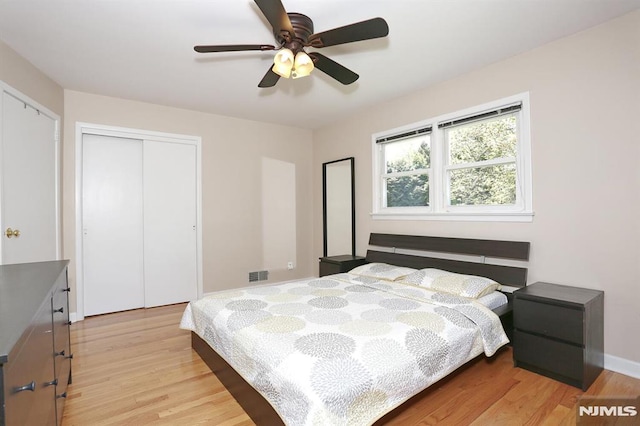bedroom featuring a ceiling fan, a closet, baseboards, visible vents, and light wood-type flooring