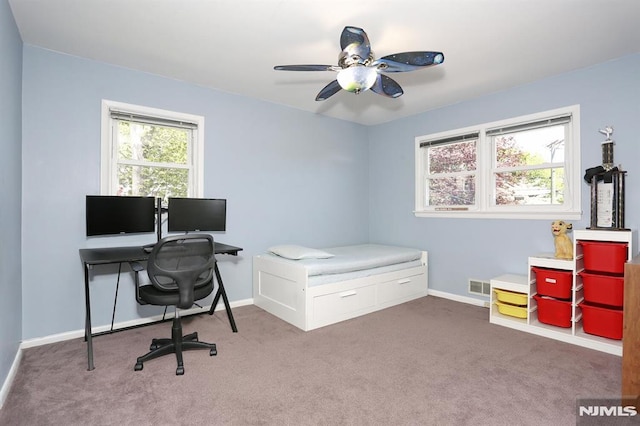 carpeted office space with baseboards, a ceiling fan, and visible vents