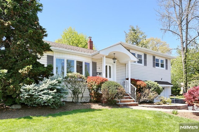 view of front of house with a chimney and a front lawn