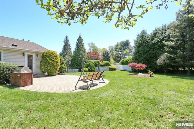 view of yard featuring a patio area, an outdoor kitchen, and fence