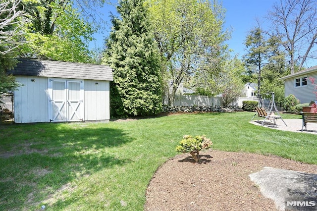 view of yard with a patio area, an outbuilding, fence, and a storage unit