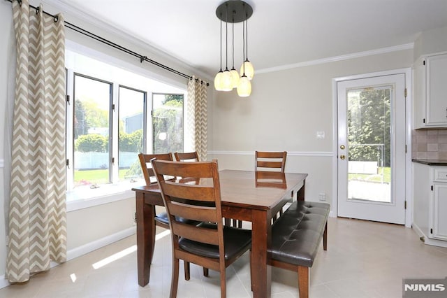 dining area with crown molding, baseboards, and a healthy amount of sunlight