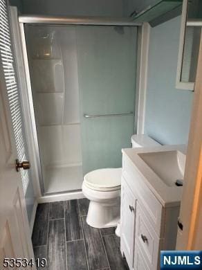 55 2nd St, South Orange Village, NJ 07079 - bathroom featuring a stall shower, toilet, vanity, and wood finish floors
