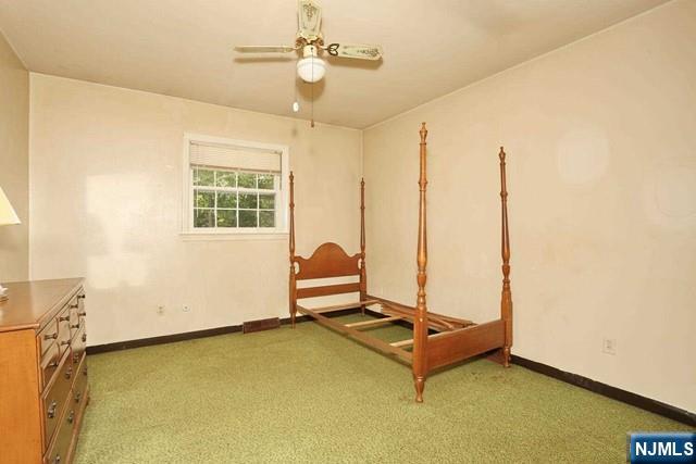 unfurnished bedroom featuring baseboards, a ceiling fan, and carpet