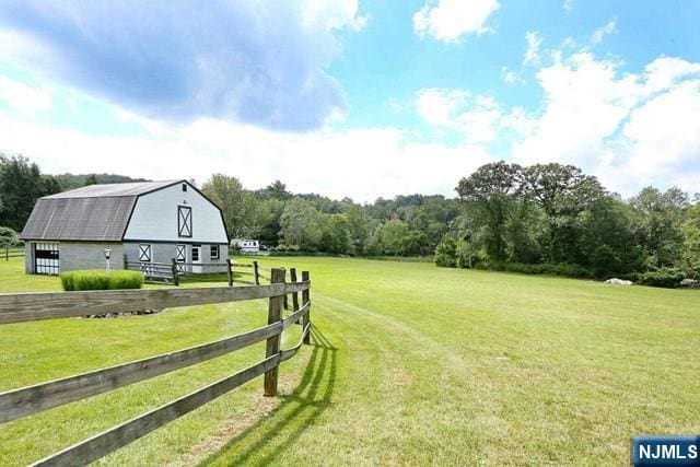 view of yard with fence, an outbuilding, and a barn