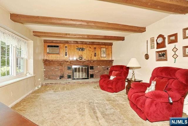 carpeted living area with a wall mounted air conditioner, beam ceiling, a fireplace, and baseboards