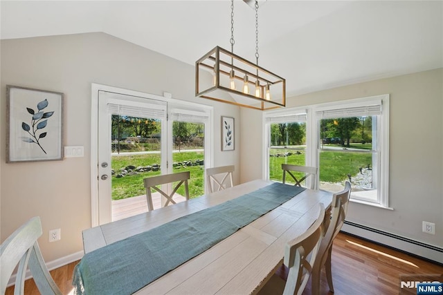 dining space featuring wood finished floors, vaulted ceiling, a baseboard radiator, a chandelier, and baseboards