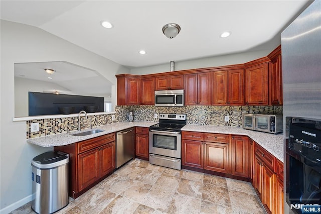 kitchen with a sink, stainless steel appliances, light stone counters, a toaster, and decorative backsplash