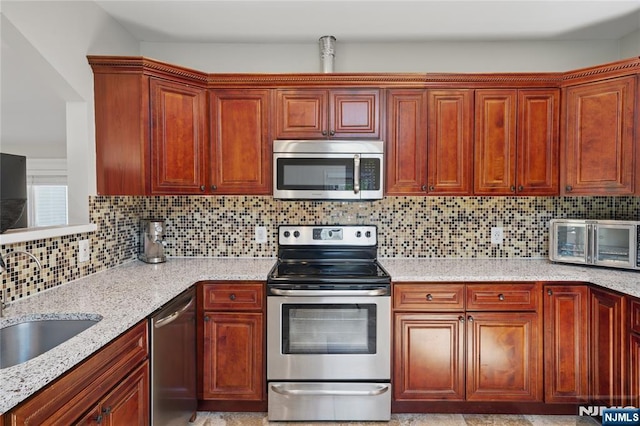 kitchen with a sink, a toaster, stainless steel appliances, light stone countertops, and tasteful backsplash