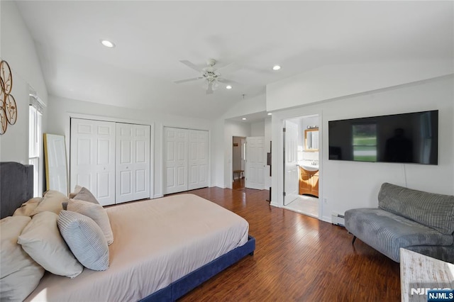 bedroom featuring lofted ceiling, recessed lighting, a baseboard heating unit, wood finished floors, and multiple closets