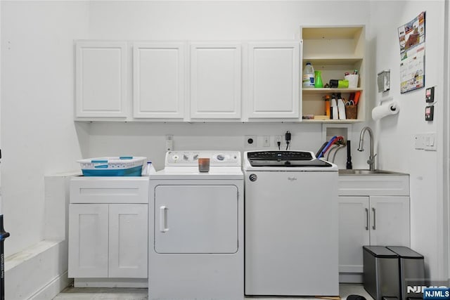 laundry room with washer and dryer, cabinet space, and a sink