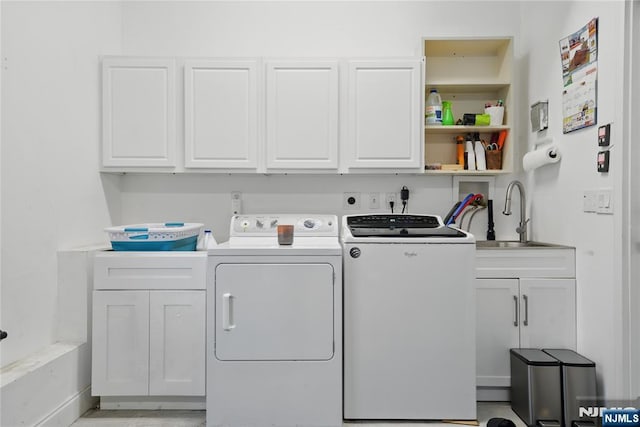 laundry area featuring a sink, cabinet space, baseboards, and independent washer and dryer