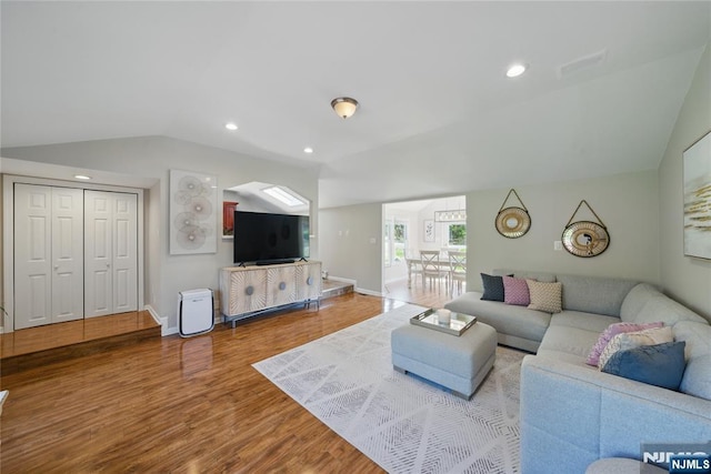 living room featuring baseboards, wood finished floors, lofted ceiling, and recessed lighting