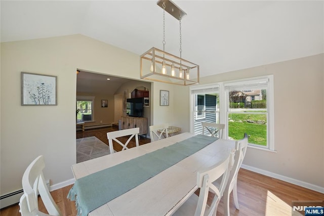 dining area with a baseboard heating unit, baseboards, wood finished floors, and vaulted ceiling