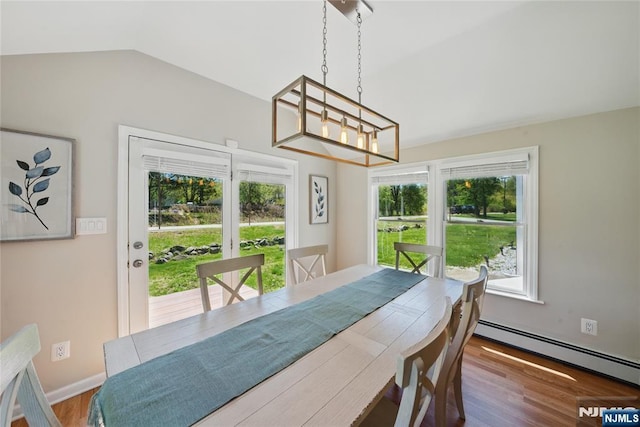 dining space with wood finished floors, a baseboard radiator, a notable chandelier, baseboards, and lofted ceiling