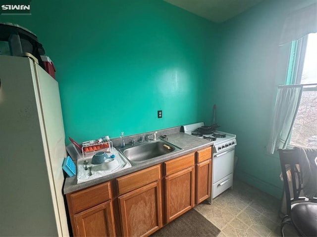 kitchen with a sink, brown cabinetry, and white appliances