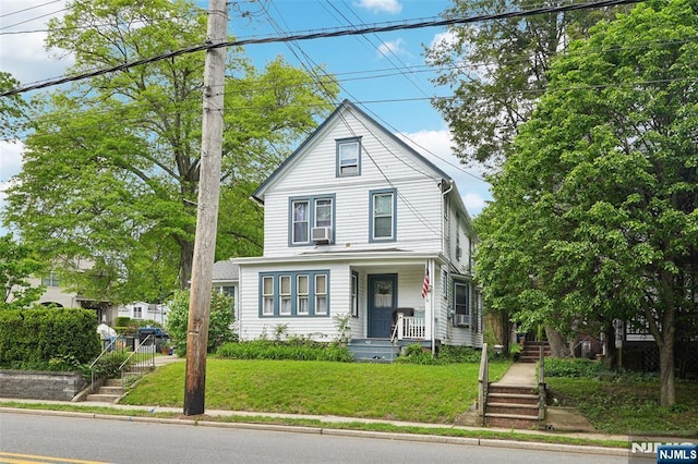 american foursquare style home with a front lawn, a porch, stairway, and cooling unit
