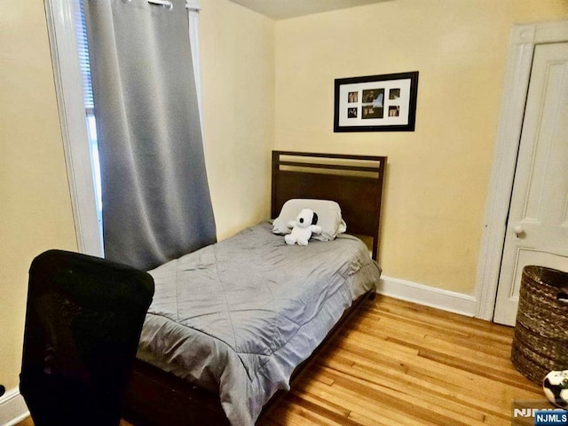 bedroom featuring wood finished floors and baseboards
