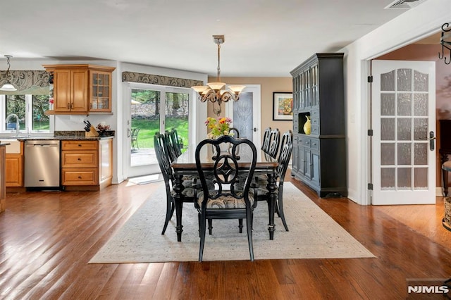 dining space featuring dark wood finished floors, a chandelier, and plenty of natural light