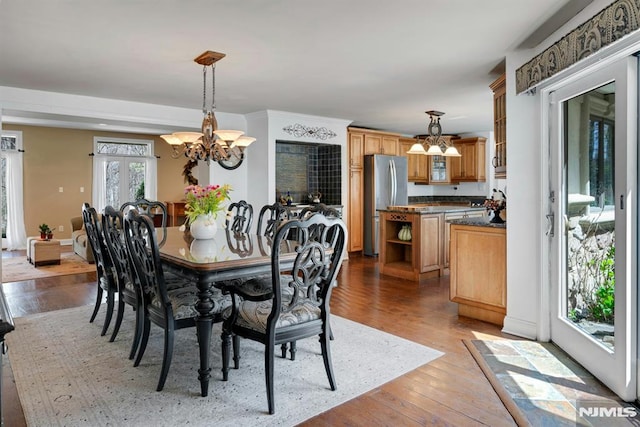 dining area featuring light wood-style floors and an inviting chandelier