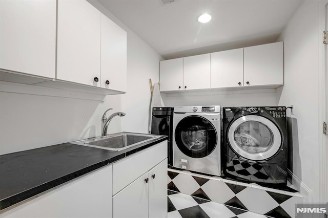 washroom with cabinet space, a sink, and washer and clothes dryer