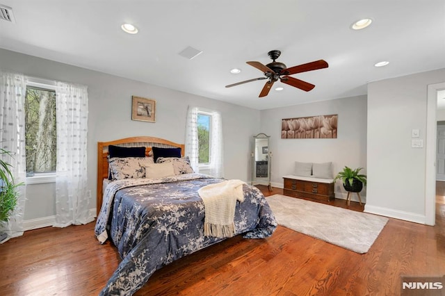 bedroom with visible vents, wood finished floors, baseboards, and recessed lighting