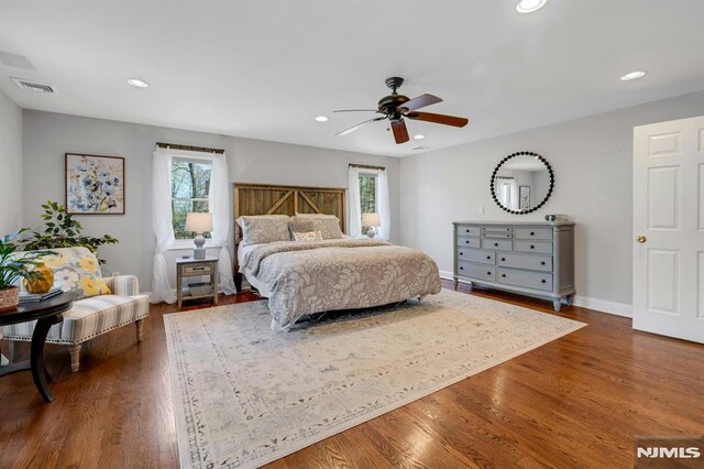 bedroom featuring multiple windows and dark wood-type flooring