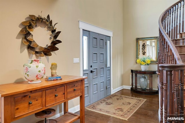 foyer entrance with baseboards, stairs, and dark wood-style floors