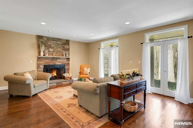 living room with a wealth of natural light, french doors, and dark wood-style floors