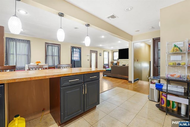 kitchen featuring wood counters, visible vents, open floor plan, and recessed lighting