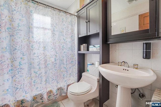 bathroom featuring toilet, tile patterned floors, tile walls, visible vents, and radiator heating unit