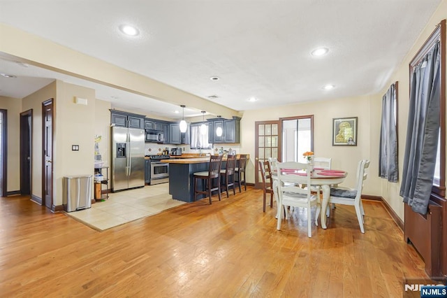 dining space with baseboards, recessed lighting, and light wood-type flooring