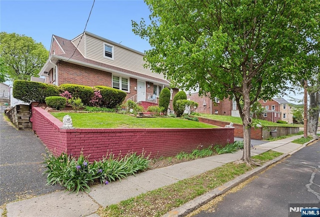 view of front of home featuring a front lawn and brick siding