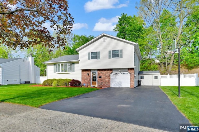 tri-level home featuring driveway, brick siding, an attached garage, and fence