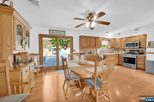 dining space featuring a healthy amount of sunlight, light wood-style flooring, and visible vents