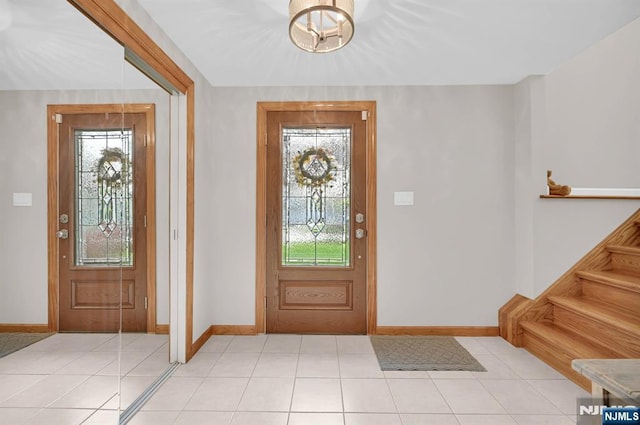 entrance foyer featuring a wealth of natural light, baseboards, and light tile patterned floors