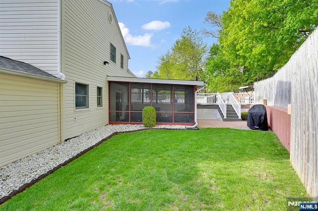 view of yard featuring a sunroom, fence, and a deck