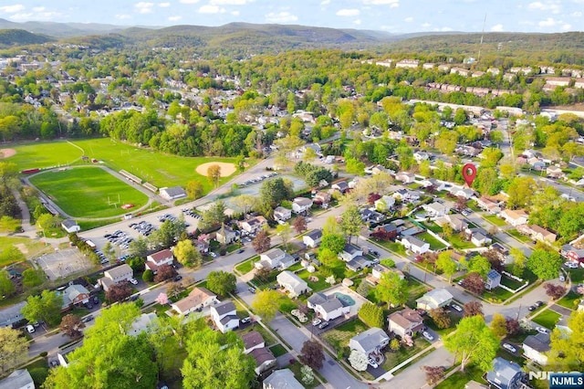 birds eye view of property with a wooded view and a mountain view