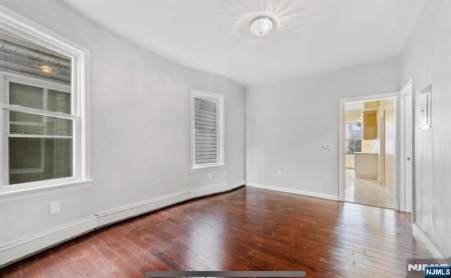 empty room featuring hardwood / wood-style flooring and baseboards