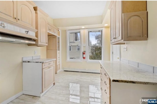 kitchen with a baseboard heating unit, light stone countertops, light brown cabinetry, and baseboards
