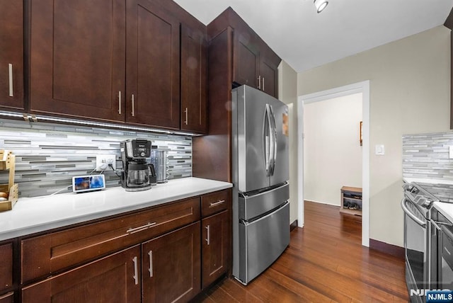 kitchen with dark brown cabinets, stainless steel appliances, dark wood-style flooring, light countertops, and tasteful backsplash
